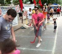 Members of the Toronto Gay Hockey Association playing ball hockey with little kids during the 2011 Pride SportZone.